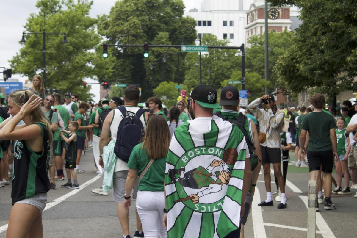 A fan wears a Boston Celtics cape and navigates the crowd. Attendees of all ages made their pilgrimage to Beantown to celebrate the historic win.